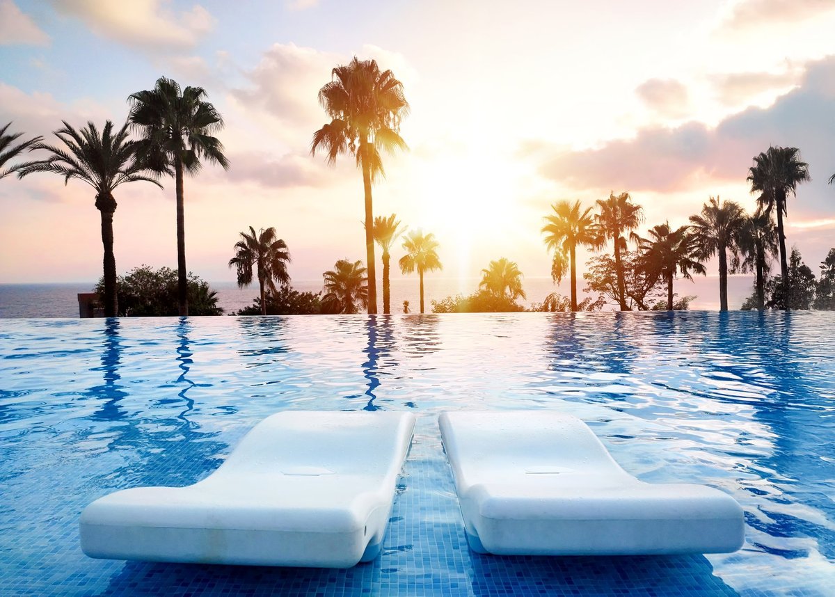Tranquil sunset view over infinity pool with palm trees tropical vacation vibes