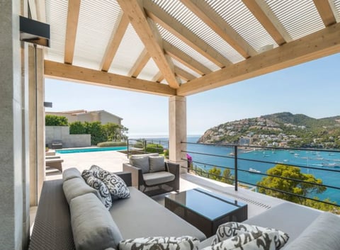 Modern pergola-covered outdoor lounge with sea views and pool