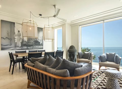 Modern beachfront penthouse interior with curved seating and ocean views
