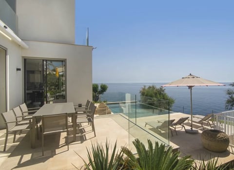 Modern waterfront terrace with dining area and sea view