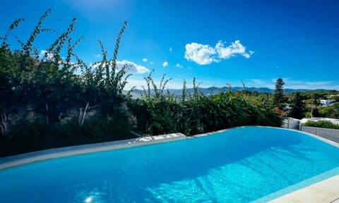 Rectangular swimming pool with clear blue water overlooking mountains and scenic landscape
